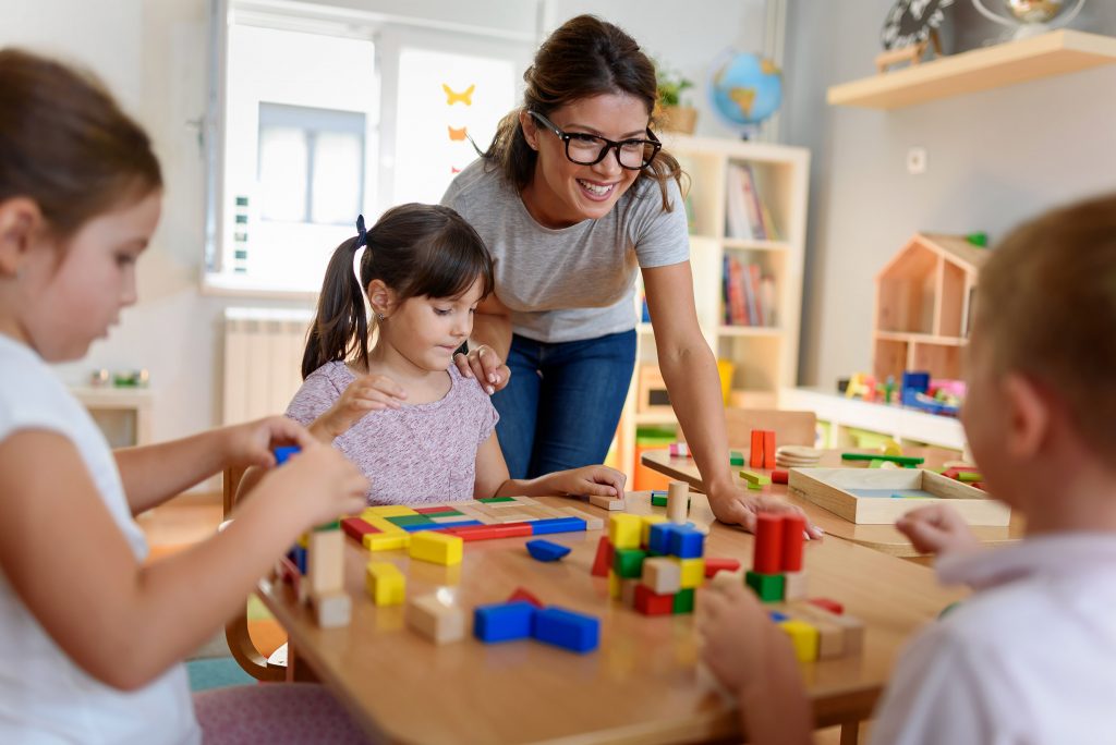 Children in Day Care Playing under Adult Supervision